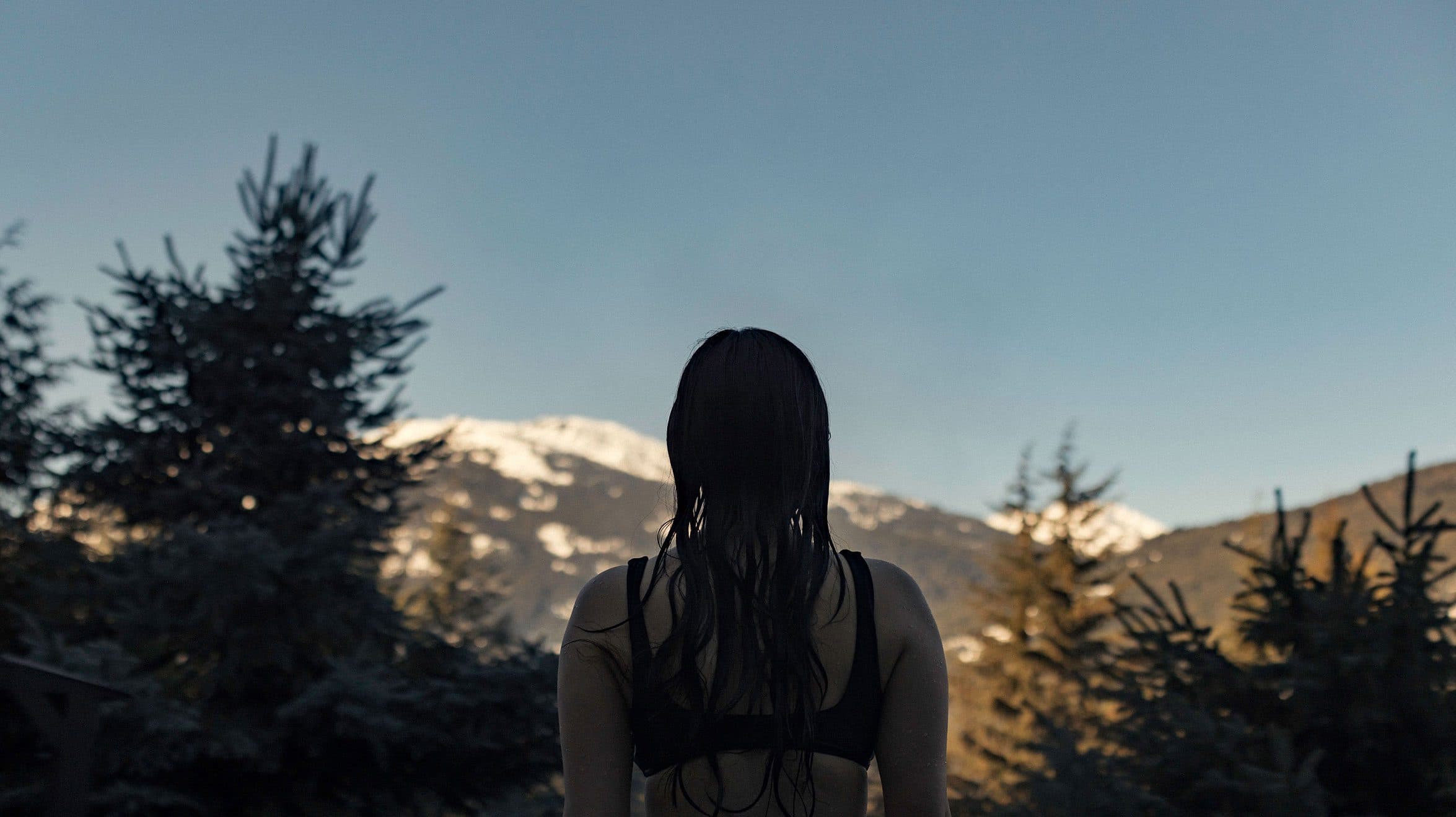 Une femme regardant le paysage magnifique des montagnes au Scandinave Spa Whistler