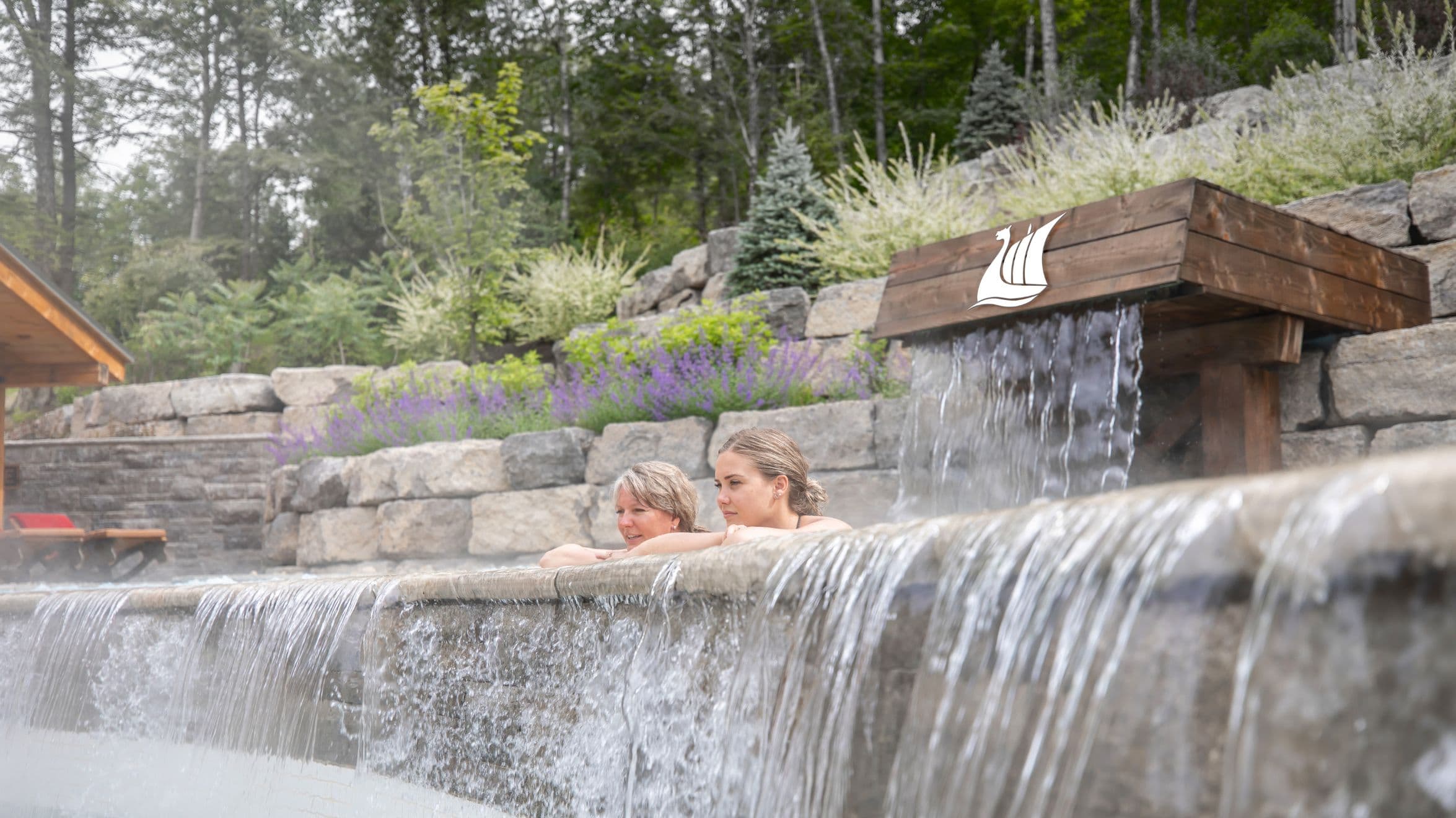 two people resting by a pool waterfall