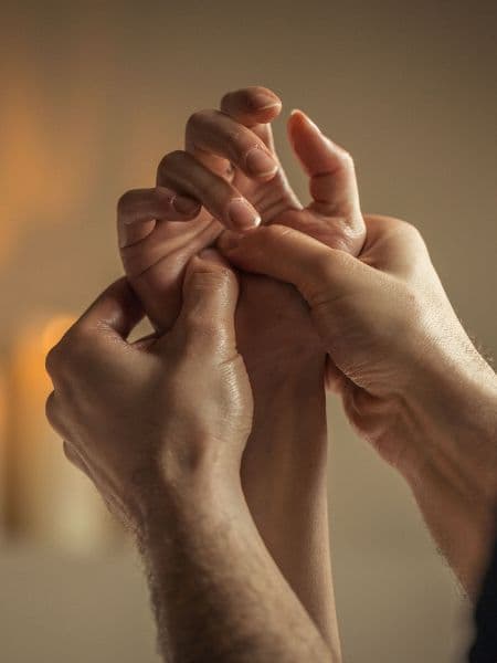 two hands massaging the palm of a hand