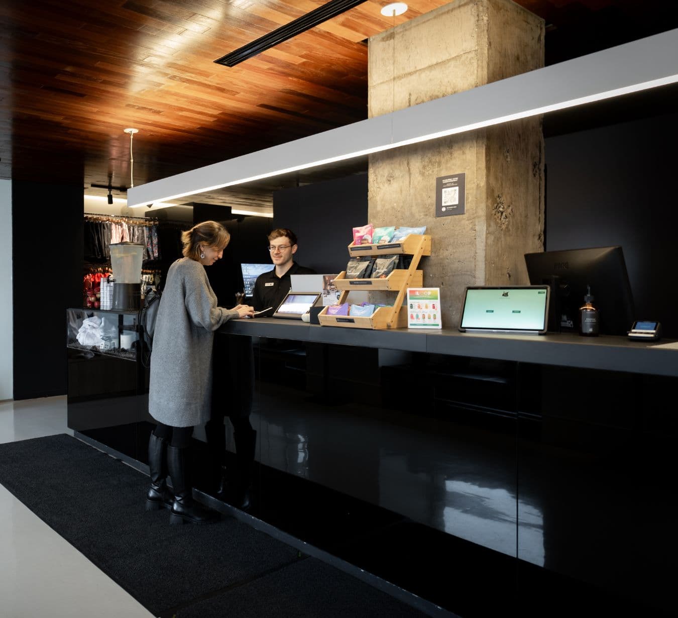 Réception du Scandinave Spa Vieux-Montréal avec comptoir d'accueil moderne. Expérience de détente urbaine, de thermothérapie et de massages.