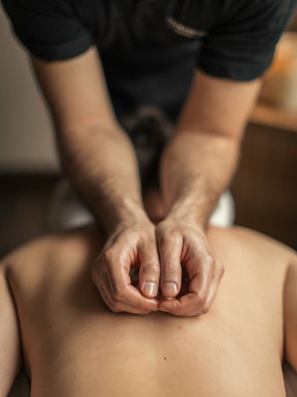 A close-up view of hands performing a back massage on a guest at Scandinave Spa Whistler, showcasing skilled and soothing therapy.