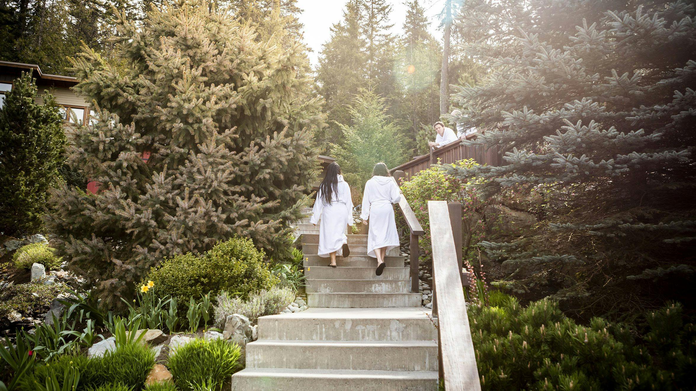 Two women walking up beautiful staircase in the Scandinave Spa Whistler Scandinavian baths area where guests enjoy thermal therapy and an adventure in wellness.