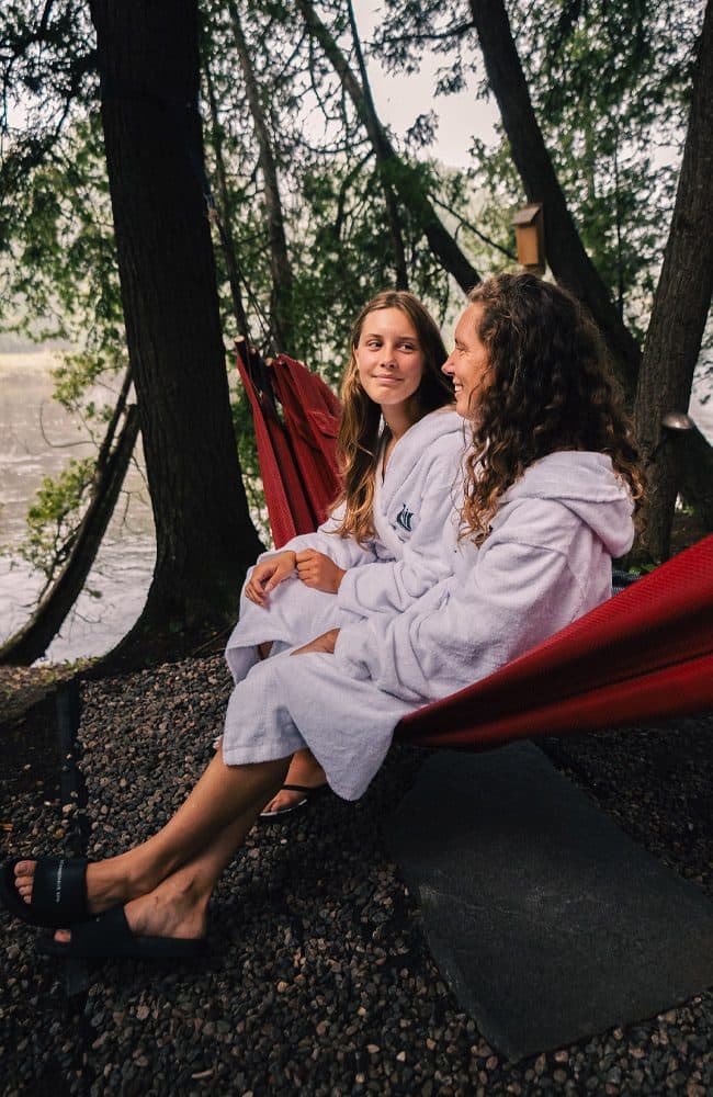 A mother and daughter enjoy the outdoor hammock section at Scandinave Spa.