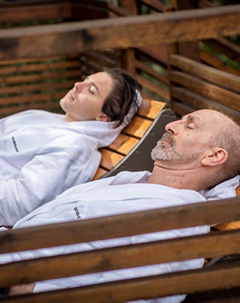A father and daughter relaxing in the outdoor lounging areas at Scandinave Spa.