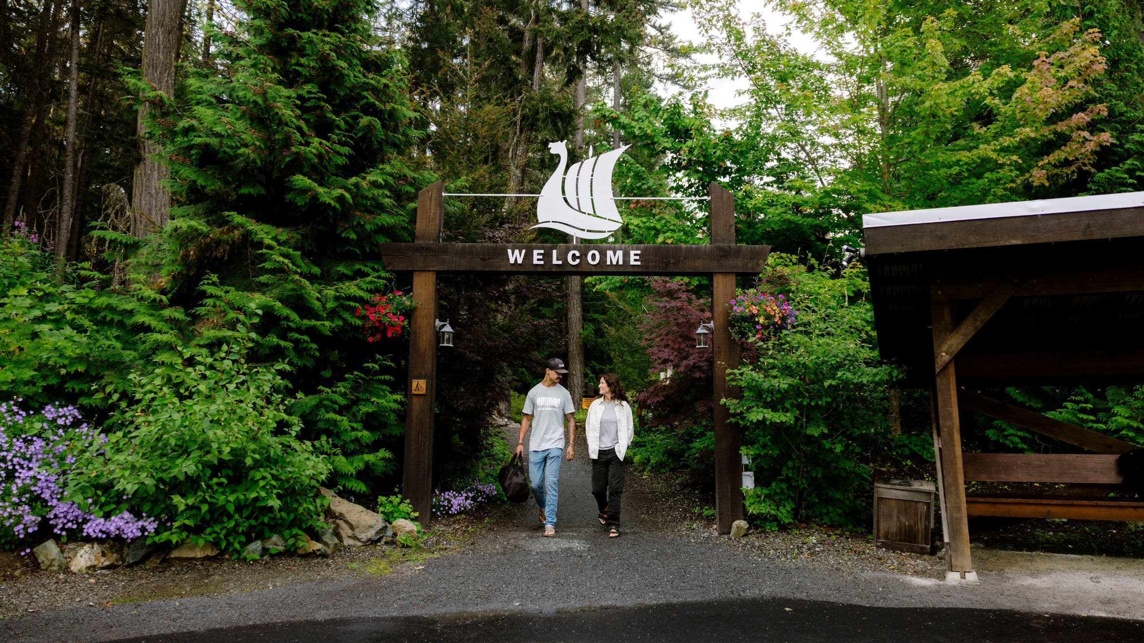 Steve Vanderhoek and his wife walking under the welcome sign at Scandinave Spa Whistler.
