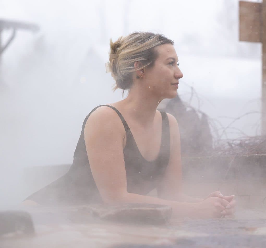 woman leaning over a waterfall at Scandinave Spa Blue Mountain.