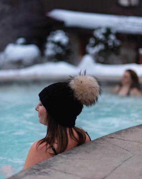 women relaxing in outdoor hot Bath in winter at Scandinave Spa Blue Mountain.