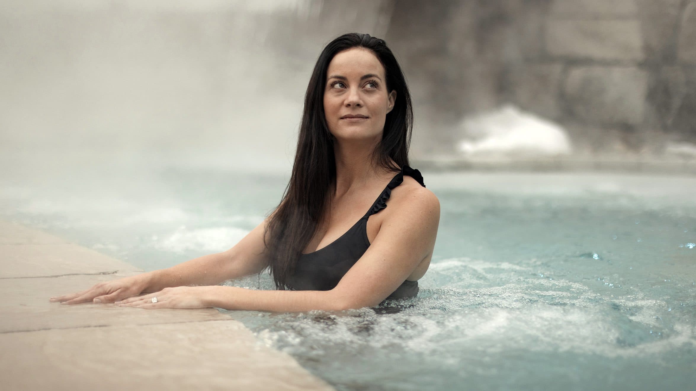 femme relaxant dans un bassin chaud au spa