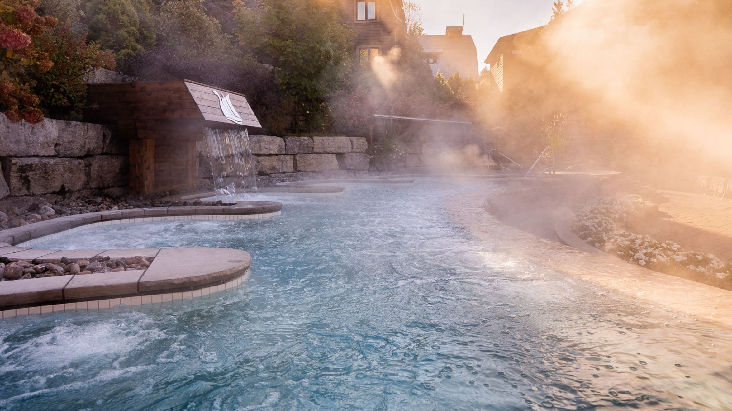 Summer view of the sauna Infinité at Scandinave Spa Mont-Tremblant, surrounded by lush greenery and perfect for disconnection.
