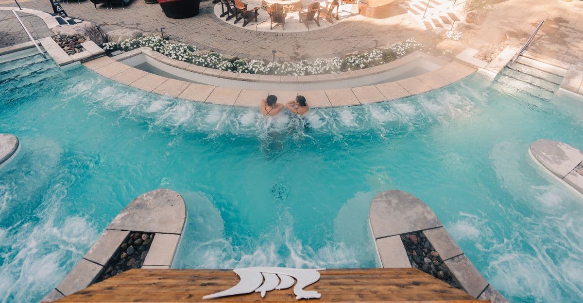 Deux femmes savourent un moment de silence dans un bassin chaud extérieur au Scandinave Spa Mont-Tremblant — une expérience de déconnexion numérique en pleine nature.