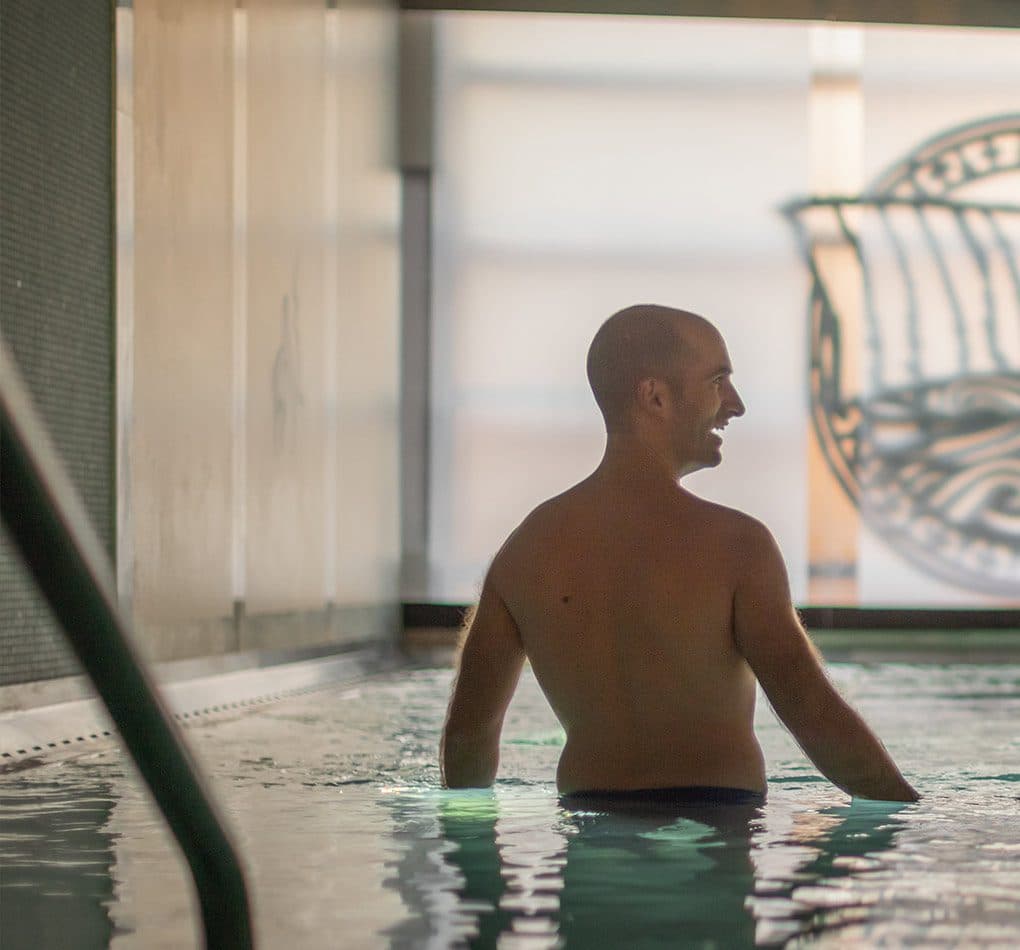 Man enjoying the hot pool at Scandinave Spa Old Montreal, part of the relaxation journey.