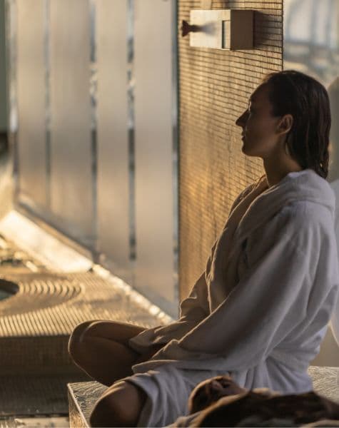 A woman relaxing on a heated bench at Scandinave Spa Vieux-Montréal.