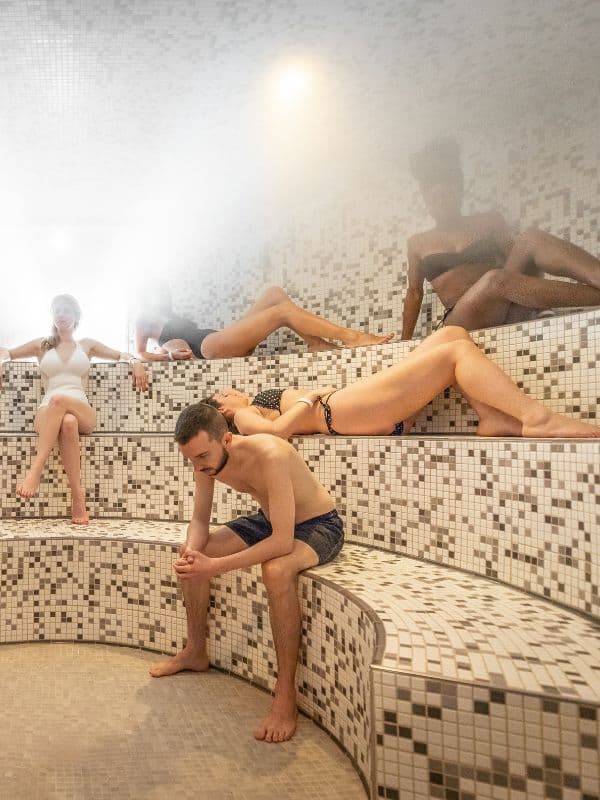 A group of people relaxing in the steam sauna at Scandinave Spa Vieux-Montréal.