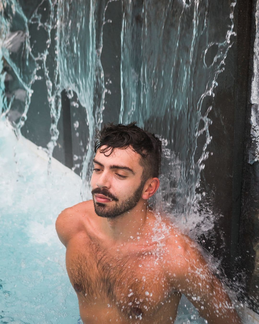 A man immersing himself in a cold plunge at Scandinave Spa Whistler, embracing the invigorating sensation.