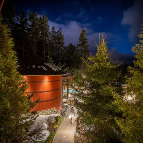 A peaceful nighttime view of Scandinave Spa Whistler, illuminated under the stars with a tranquil atmosphere.